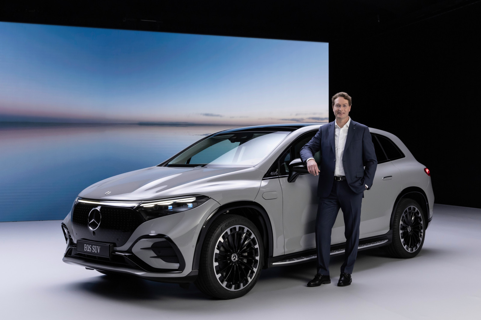 Mercedes CEO Ola Källenius neben einem EQE-SUV – wenn es nach ihm geht, sollen Kunden auch nach 2030 einen Verbrenner kaufen können.